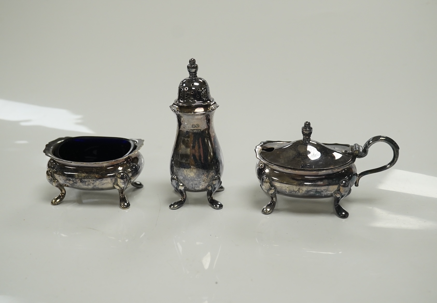 A cased 1960's three piece silver condiment set by William Suckling Ltd and and a cased pair of George III silver berry spoons, George Smith IV, London, 1812. Condition - fair